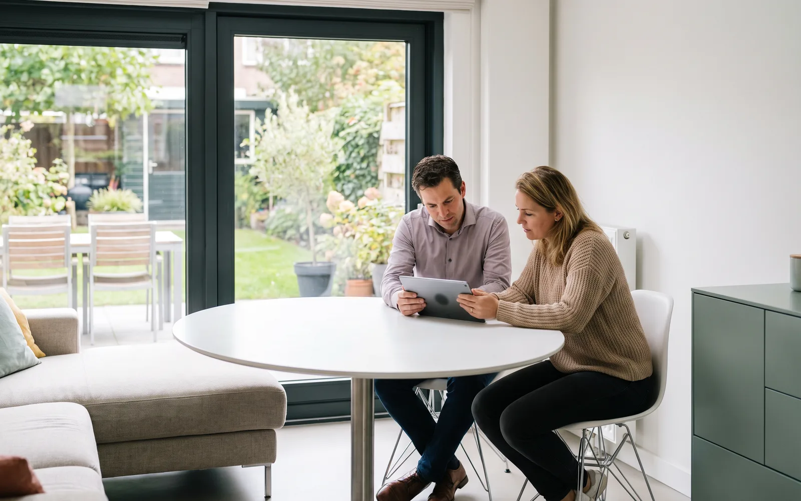 Een adviseur van ons loopt met een bewoner de begroting door in haar lichte woonkamer