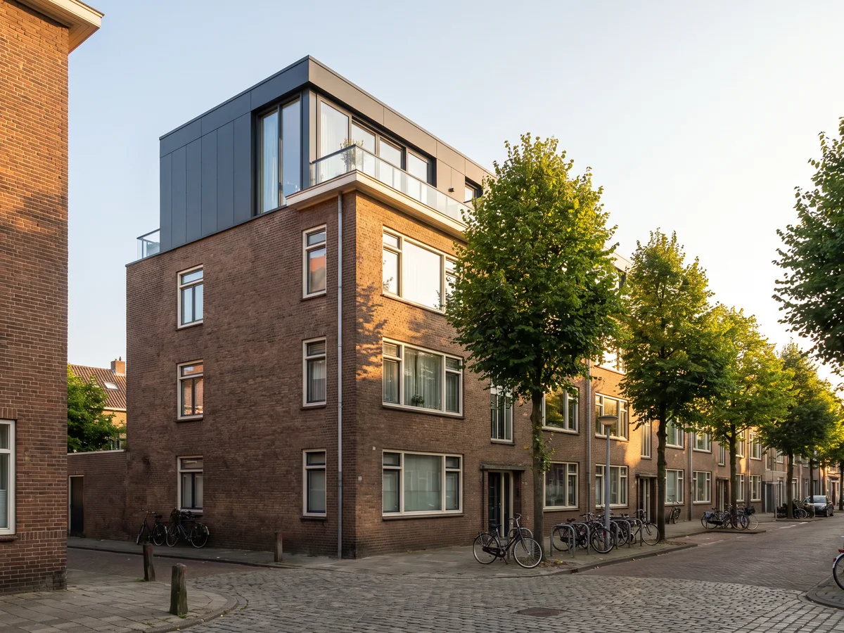 Een klein appartementengebouw met een nieuwe, terugliggende laag in antraciet bovenop